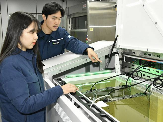 액침냉각설비에 담긴 냉각유와 서버를 테스트하고 있는 HD현대오일뱅크 직원들.(사진=HD현대오일뱅크)