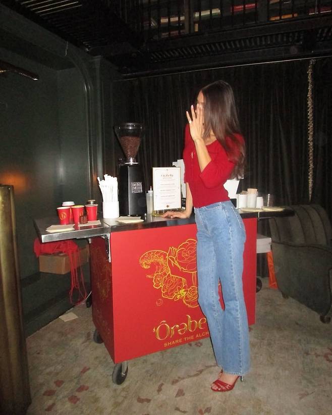 레드 톱과 데님 진의 조합으로 홀리데이 무드를 낸 벨라 하디드. 인스타그램 @bellahdid