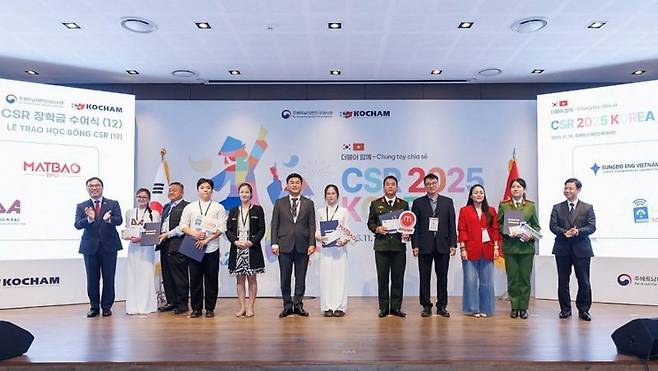 최영삼 주베트남 한국대사(왼쪽 첫번째)를 비롯한 기업 관계자들이 26일 하노이에 열린 '2025년 더불어 함께, 한국 CSR의 날' 행사에서 베트남 우수 대학생들에게 장학금을 전달하고 환하게 웃고 있다. 베트남 재무부 제공