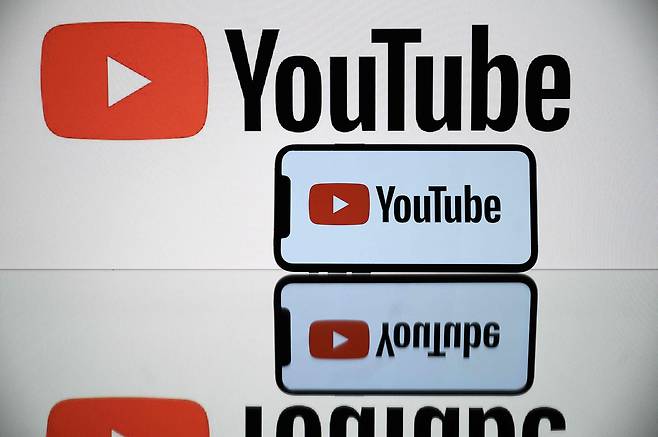 A picture taken on Oct. 5, 2021 shows the logo of Youtube social media displayed by a by a tablet and a smartphone [AFP/YONHAP]