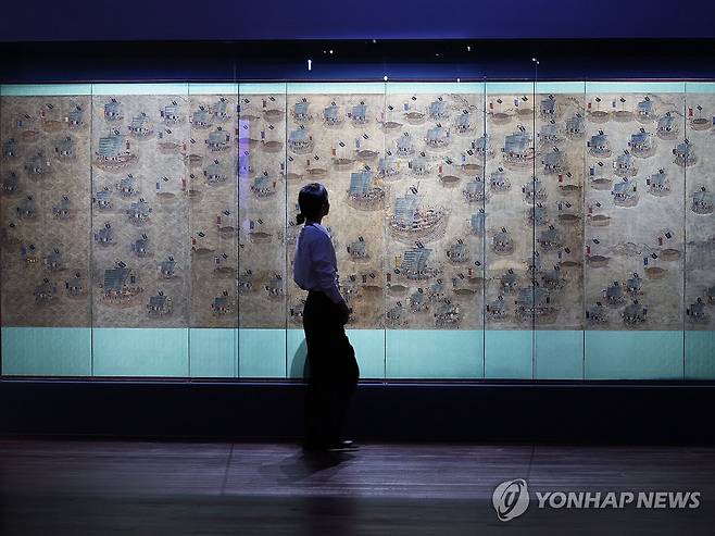 수군의 훈련 모습 '수군조련도병' (서울=연합뉴스) 강민지 기자 = 27일 서울 용산구 국립중앙박물관에서 열린 '우리들의 이순신' 전시 언론공개회에서 참석자가 '수군조련도병'을 둘러보고 있다. 충무공 탄신 480주년과 광복 80주년을 맞아 선보이는 전시는 다음 달 4일까지는 무료 개방한다. 2025.11.27  mjkang@yna.co.kr