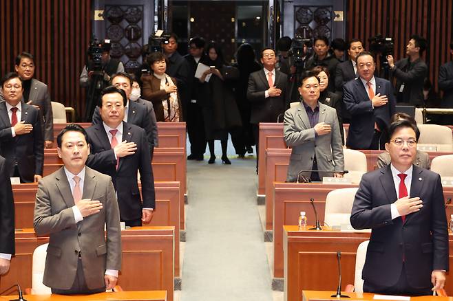 장동혁 대표와 송언석 원내대표 등 국민의힘 의원들이 지난 27일 서울 여의도 국회에서 열린 의원총회에서 국기에 경례하고 있다. [연합뉴스]