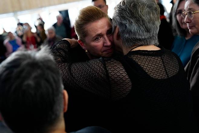 메테 프레데릭센 덴마크총리가 지난 9월 24일 그린란드 누크의 카투악 문화관에서 회의를 마친 후 한 여성과 포옹하고 있다. 덴마크의 메테 프레데릭센 총리는 이날 덴마크의 자치령인 그린란드를 방문해 코펜하겐이 30년 이상 운영한 강제 피임 프로그램의 피해자들에게 직접 사과했다. [AFP]