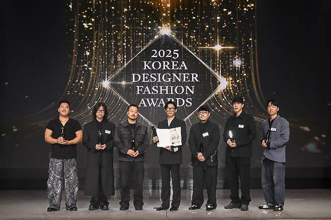 2025 한국디자이너패션어워즈 수상 디자이너들이 기념촬영을 하고 있다. 왼쪽부터 유강현, 박상조, 김지용, 김인태, 김지만, 이진호, 장세훈. 한국패션디자이너연합회 제공