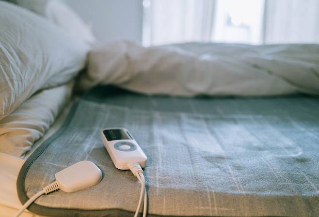 침대 위에 놓인 전기장판과 조절기. 겨울철 사용 전 점검이 필수적이다. 게티이미지뱅크