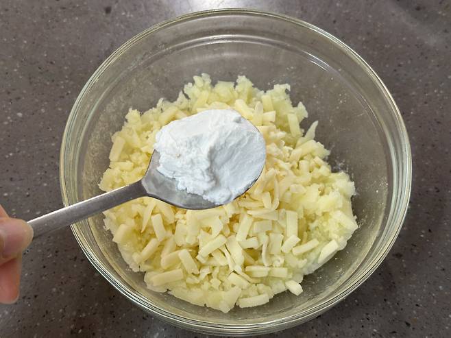 모짜렐라 치즈 위에 넣으려는 감자전분이 소복이 담긴 숟가락