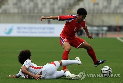 2014년 인천 아시안게임 남자축구 경기에서 한국 선수의 태클을 피하는 북한 선수 모습 [연합뉴스 자료사진]