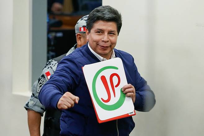 27일(현지시간) 페루 리마 대법원 특별형사재판부에서 열린 공판에서 페드로 카스티요 전 페루 대통령이 ‘페루를 위한 함께’ 정당 로고를 보여주며 사진촬영하고 있다. [EPA 연합뉴스]