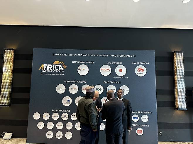 아프리카투자포럼(AIF) 주요 후원자인 일본과 중국(오른쪽 상단) (라바트=연합뉴스) 김성진 기자 = 28일(현지시간) 모로코 수도 라바트의 소피텔 호텔의 AIF 행사장에 내걸린 후원사 표시판 앞에서 참가자들이 담소하고 있다. 2025.11.28 sungjin@yna.co.kr