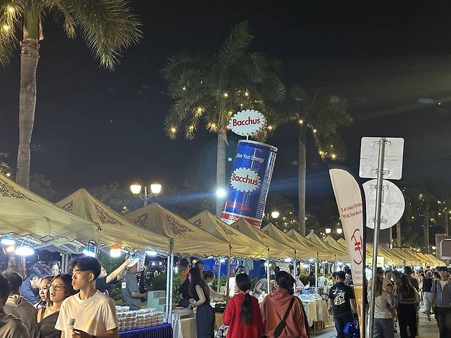 A huge replica of a can of Korean energy drink Bacchus rises above the Walking Street crowds in Phnom Penh, Cambodia on Nov. 22.  [JIM BULLEY]