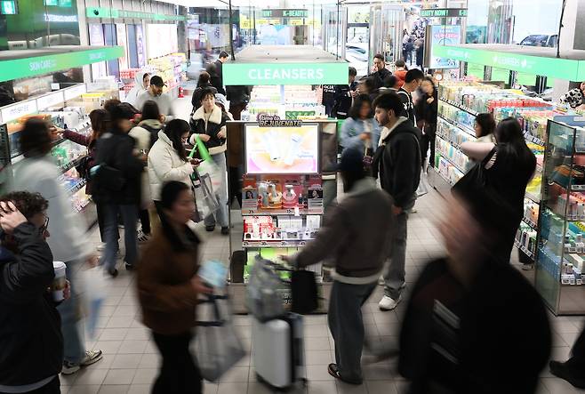 Foreign customers shop for cosmetics products at an Olive Young store in Seoul on Nov. 24. [YONHAP]