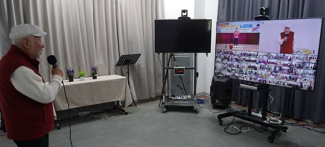 ㈜욱성미디어는 1일 대전 유성구 본사에서 시니어 복지 서비스인 '화상돌봄시스템' 홍보대사로 가수 김도향 씨를 위촉했다. 김도향 가수가 이날 본사에서 실시간 화상 프로그램을 통해 충남 공주지역 경로당 어르신들과 소통하고 있다. /김흥수 기자