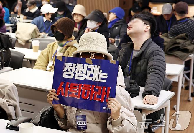 1일 오후 서울 여의도 더불어민주당사 당원존에서 민주당 대의원·전략지역 당원 역할 재정립 태스크포스(TF) 주최로 열린 '당원 주권 정당 실현을 위한 제도개선 토론회'에서 한 당원이 정청래 대표 사퇴를 촉구하는 내용의 손팻말을 들고 있다. 2025.12.1/뉴스1 ⓒ News1 구윤성 기자