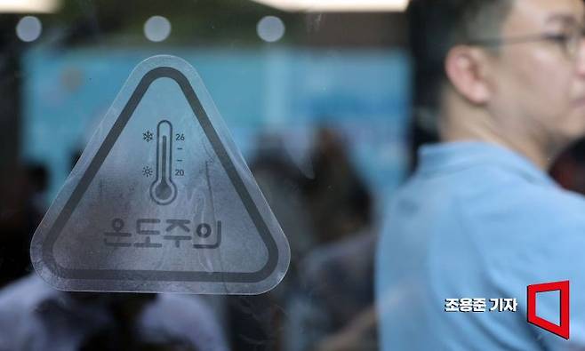 10일 서울 명동에서 열린 여름철 에너지절약 캠페인 출범식에서 한 카페 문에 캠페인 동참 스티커가 부착되어 있다. 사진=조용준 기자 jun21@