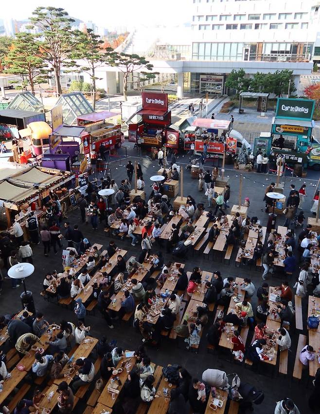 지난달 27일부터 영화의전당 야외광장 일대에서 열리고 있는 ‘크리스마스 빌리지 부산’ 행사에서 사람들이 다양한 겨울 음식을 즐기고 있는 모습. 영화의전당 제공
