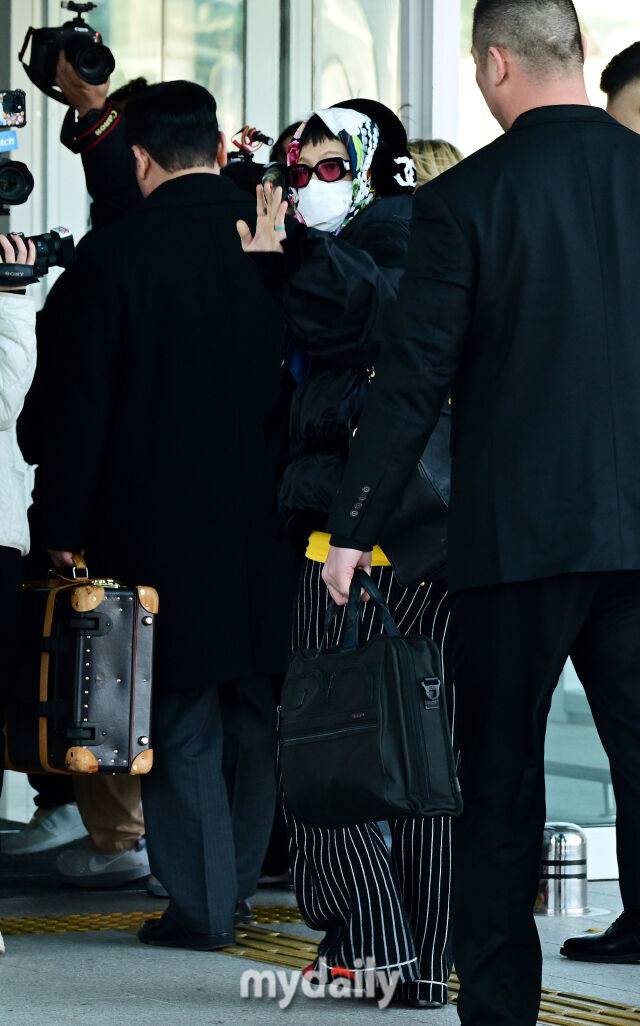 출국하는 지드래곤이 취재진을 향해 손을 흔들고 있다.