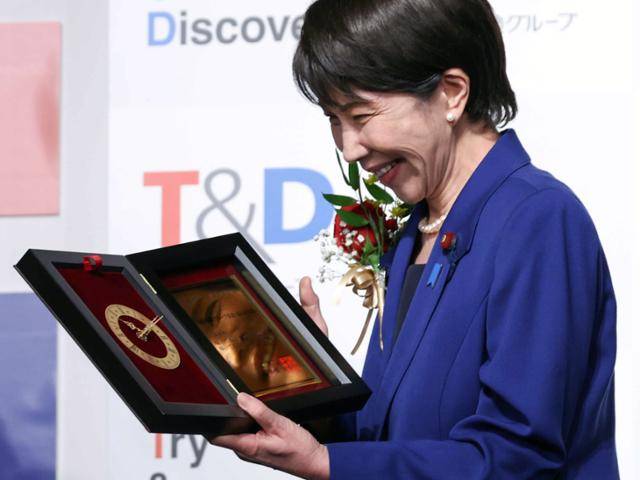 다카이치 사나에 총리가 1일 도쿄에서 열린 '올해의 유행어상' 시상식에서 상장을 보며 환하게 웃고 있다. 도쿄=지지·EPA 연합뉴스