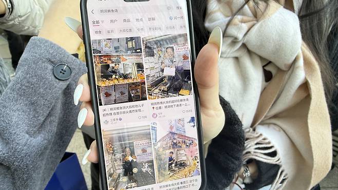 Lucy shows a screen displaying the famous bungeoppang stall. [WOO JI-WON]