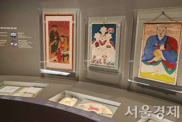 아이를 안고 있는 무학대사를 그린 무신도(오른쪽) 등 출산 관련 부적과 그림.