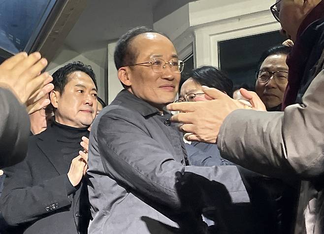 Rep. Choo Kyung-ho (center) of the main opposition People Power Party on Wednesday is being applauded by his supporters in front of the Seoul Detention Center in Gyeonggi Province on Wednesday, after the court rejected the special counsel's request for his arrest warrant. (Yonhap)