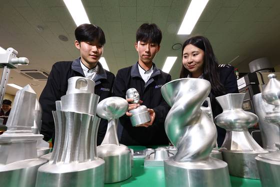 Students examine an aluminum model made with a five-axis machining center at Suwon Hi-tech High School in Suwon, Gyeonggi on Nov. 17. [KIM JONG-HO]