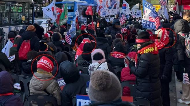 3일 오후 서울 영등포구 국회의사당역 3번 출구 앞에서 열린 시민단체 '신자유연대' 집회에 참여한 시민들의 모습. '윤어게인'이 적힌 붉은색 목도리를 목과 머리에 두르고 있다. /사진=최문혁 기자