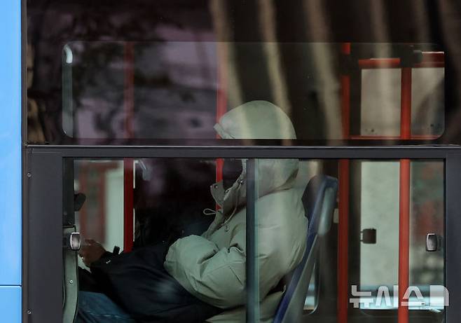 [서울=뉴시스] 이영환 기자 = 서울의 아침 기온이 영하 8도를 보이며 강추위가 찾아온 3일 오전 서울 종로구 광화문 네거리를 지나는 버스에서 한 시민이 두꺼운 옷을 입고 자리에 앉아 있다. 2025.12.03. 20hwan@newsis.com