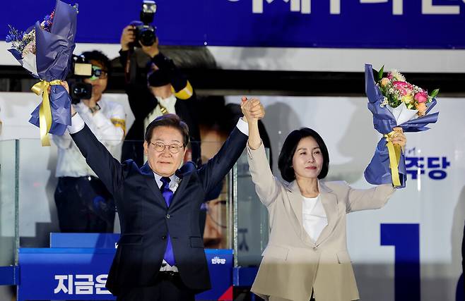 ▲&nbsp;지난 6월 서울 영등포구 국회대로에 마련된 개표 방송 시청 행사에서 제21대 대통령 당선이 확실시된 더불어민주당 이재명 대선 후보와 부인 김혜경 여사가 꽃다발을 들고 시민들을 향해 인사하고 있다. /인천일보DB