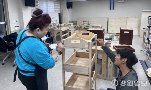 ◇춘천 마을창작공작소 집수리도서관에서 목공 프로그램을 듣는 최혜령(51)씨가 4단 수납장 원목에 바니쉬 작업을 하고 있다. 사진=고은기자