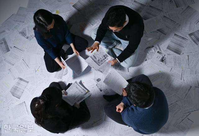 한국일보는 1979년 10월~1981년 1월 비상계엄 당시 검열 삭제당한 본보 기사 352개를 입수해 분석했다. 사진은 관련 자료 복사본을 깔아놓고 내용을 살펴보고 있는 기자들의 모습. 강예진 기자