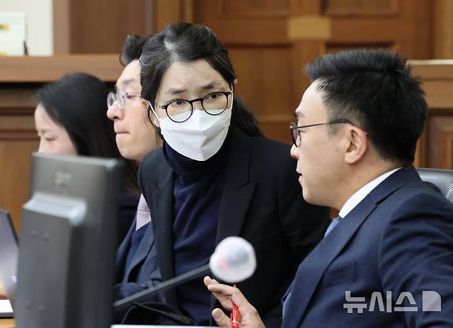 [서울=뉴시스] 사진공동취재단 = 도이치모터스 주가조작과 명태균 공천개입, 통일교 청탁·뇌물 수수 의혹 혐의 등으로 구속기소 된 김건희 씨가 3일 서울 서초구 서울중앙지방법원에서 열린 자본시장법 위반 혐의 결심 공판에 출석해 변호인과 대화하고 있다. 2025.12.03. photo@newsis.com