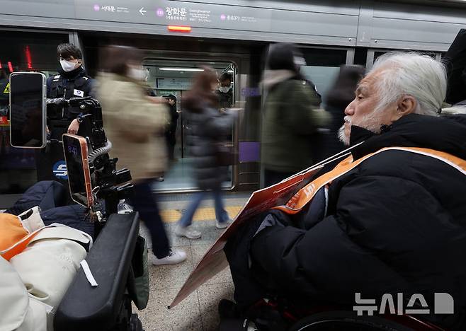 [서울=뉴시스] 이영환 기자 = 박경석 전국장애인차별철폐연대(전장연) 상임공동대표가 4일 오전 서울 종로구 지하철5호선 광화문역에서 열린 '제67차 출근길 지하철 탑니다’ 시위에 참석해 출근길 시민들을 바라보고 있다. 2025.12.04. 20hwan@newsis.com