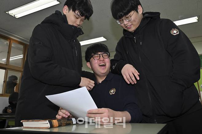 2026학년도 대학수학능력시험(수능)에서 만점을 받은 광남고 왕정건(가운데) 군이 5일 성적통지표’를 받고 친구들로부터 축하를 받고 있다. (사진=김태형 기자)