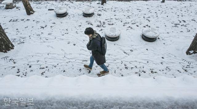 폭설 후 한파로 내린 눈이 얼어붙은 5일 오전 서울 중구 덕수궁 옆으로 한 시민이 출근길 발걸음을 옮기고 있다. 류효진 선임기자