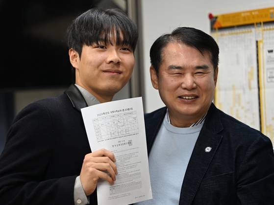 2026학년도 수능 성적표 배부일인 5일 오전 광주 서구 서석고등학교에서 수능 만점자 재학생 최장우군이 이정선 광주시교육감과 기념사진을 찍고 있다. 뉴시스