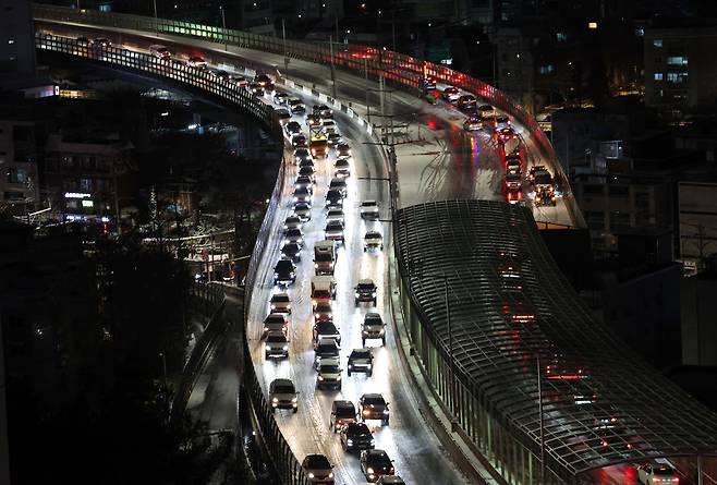 Vehicles crawl along the icy road on the Inner Beltway in Hongje-dong, Seodaemun District, western Seoul, on Dec. 4, as the capital saw its first heavy snowfall of the winter. [YONHAP]