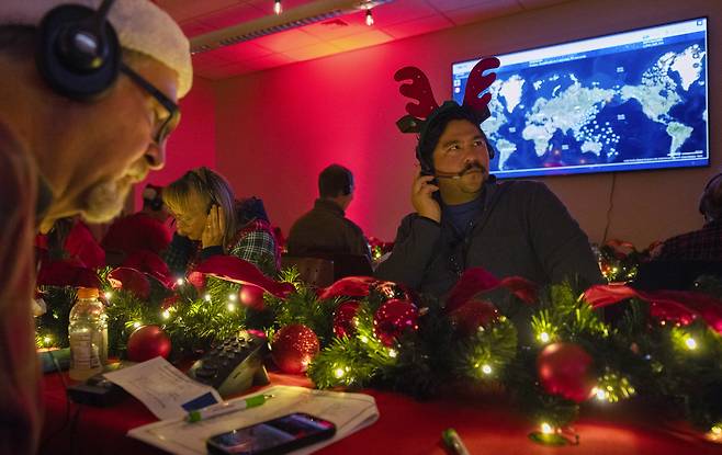 Volunteers answer phone calls from around the world on Dec. 24, 2024, at the Norad Tracks Santa center at Peterson Space Force Base in Colorado Springs, Colorado. [AP/YONHAP]