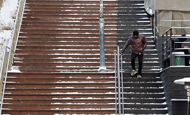 A pedestrian walks carefully on an icy staircase near Itaewon Station in central Seoul on Dec. 5 as a cold snap freezes roads following heavy snowfall. [YONHAP]