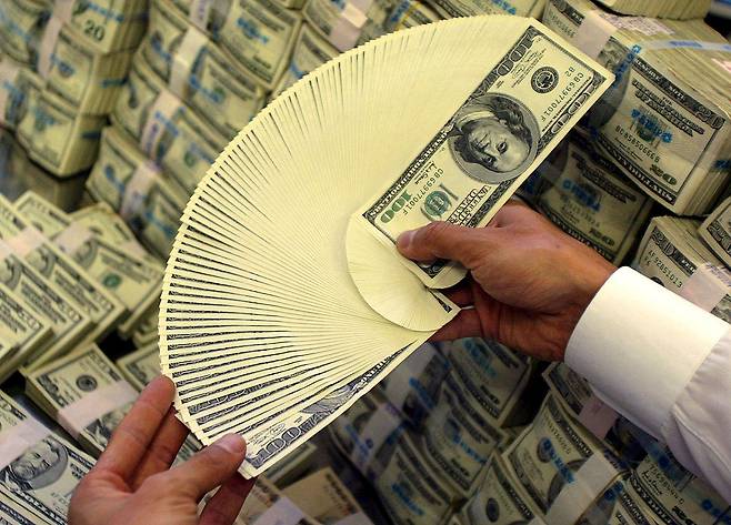 한 외환 딜러가 달러를 세고 있다.[게티이미지]