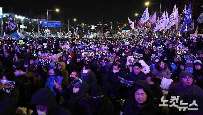 12·3 비상계엄 1년을 맞은 3일 오후 서울 영등포구 국회의사당에서 앞에서 열린 '12·3 내란·외환 청산과 종식, 사회대개혁 시민대행진' 행사에 참가한 시민들이 피켓과 응원봉을 들고 있다. 박종민 기자