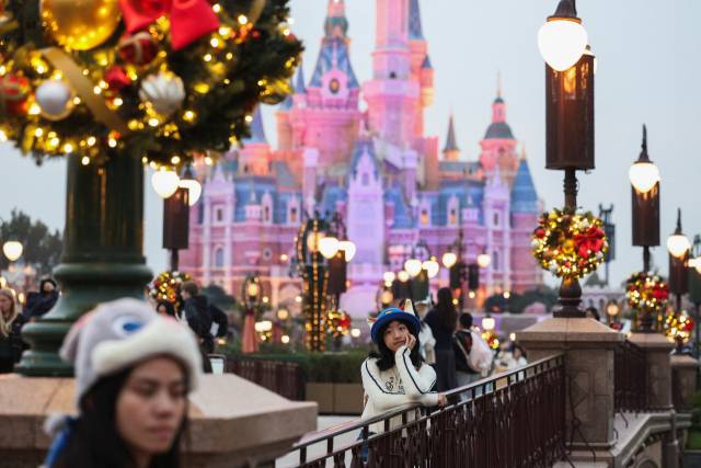 24일 중국 상하이의 디즈니랜드에서 한 공원 방문객이 크리스마스 장식 사이에 서 있다. 한국인에 대한 중국의 무비자 정책이 시행된 이후 상하이에는 한국인 관광객이 급증하고 있다. 로이터연합.