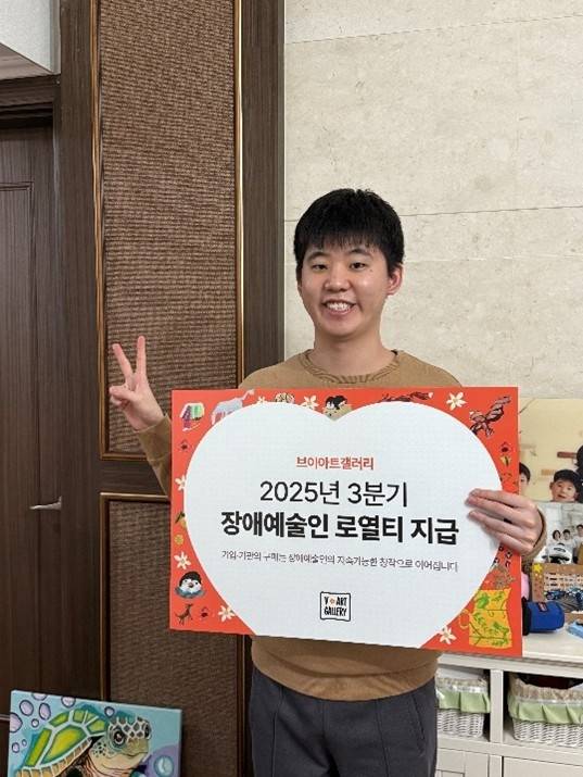 브이아트 브릿지 (V-art Bridge) 시스템 도입 이후 첫 로열티를 받은 정진우 장애 예술인이 기념 촬영을 하고 있다. 브이드림