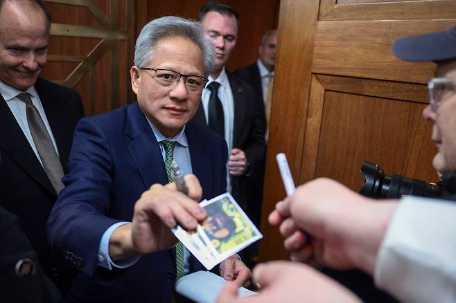 지난 3일 미국 워싱턴 D.C. 의사당(캐피톨 힐)에서 열린 상원 은행위원회 회의에 참석하기에 앞서, 엔비디아 창업자이자 CEO인 젠슨 황이 팬들에게 사인을 해주고 있다. 로이터