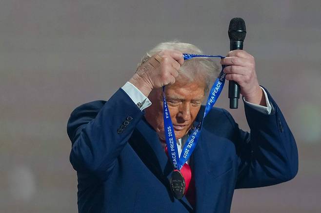 U.S. President Donald Trump puts on the FIFA Peace Prize from FIFA President Gianni Infantino at the Kennedy Center in Washington on Dec. 5. [YONHAP/AFP]