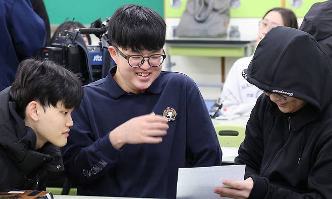2025학년도 대학수학능력시험 성적표가 배부된 5일 오전 서울 광진구 광남고등학교에서 '수능 만점자' 왕정건 학생이 성적표를 확인하며 친구들의 축하를 받고 있다. 뉴스1