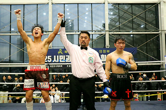 강성철이 2025년 12월 경기도 의정부시청 모두의 운동장 동양태평양복싱연맹 슈퍼페더급 실버 챔피언결정전 나병조 주심의 승리 선언에 기뻐하고 있다. 오른쪽은 판정패를 당한 서로준. 사진=KBM 한국복싱커미션