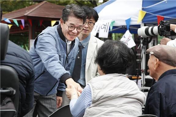 성동구 주민과 손을 잡고 이야기를 나누고 있는 정원오 성동구청장. /성동구