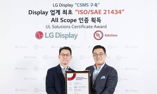 권극상 엘지디스플레이 오토사업그룹장(왼쪽)이 정륜 유엘(UL)솔루션즈 한국지사장으로부터 ‘자동차 사이버보안 엔지니어링 국제 표준’ 인증서를 전달받고 있다. 엘지디스플레이