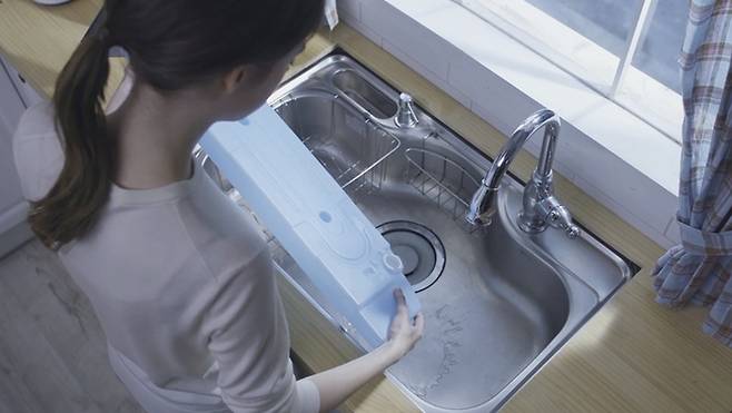 건조기에 설치된 물통을 비우는 모습.[LG전자]