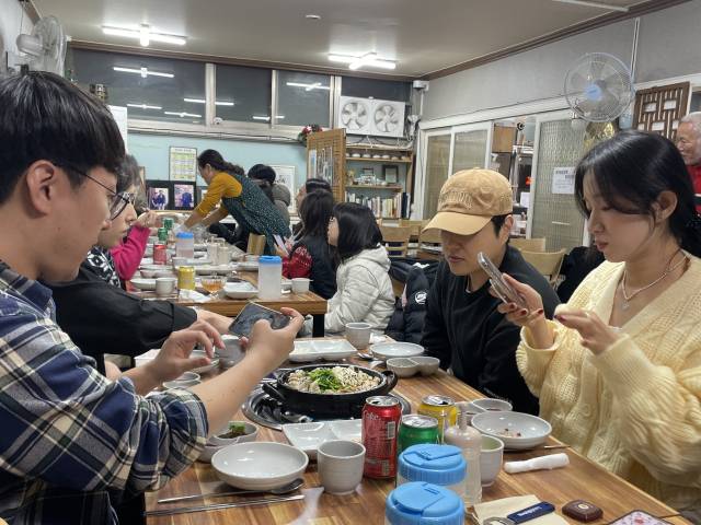 우해이어보 투어 참가자들이 우해이어보 속 어류를 활용한 코스요리 체험에서 나온 아구수육 사진을 찍고 있다.